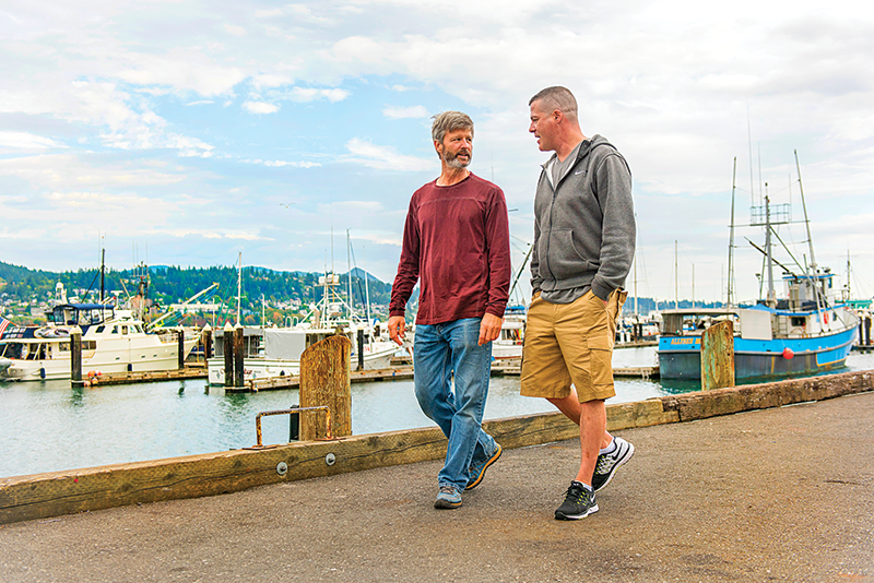 Father and Son walking down fishing dock